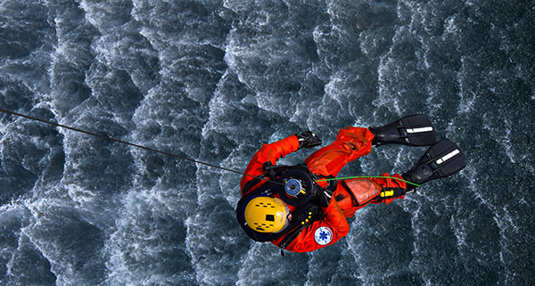 High Angle View Of Rescue Worker Over Water Hanging From Rope